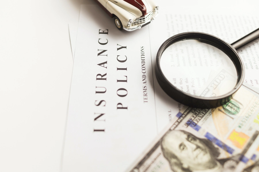 insurance policy papers with a magnifying glass on top